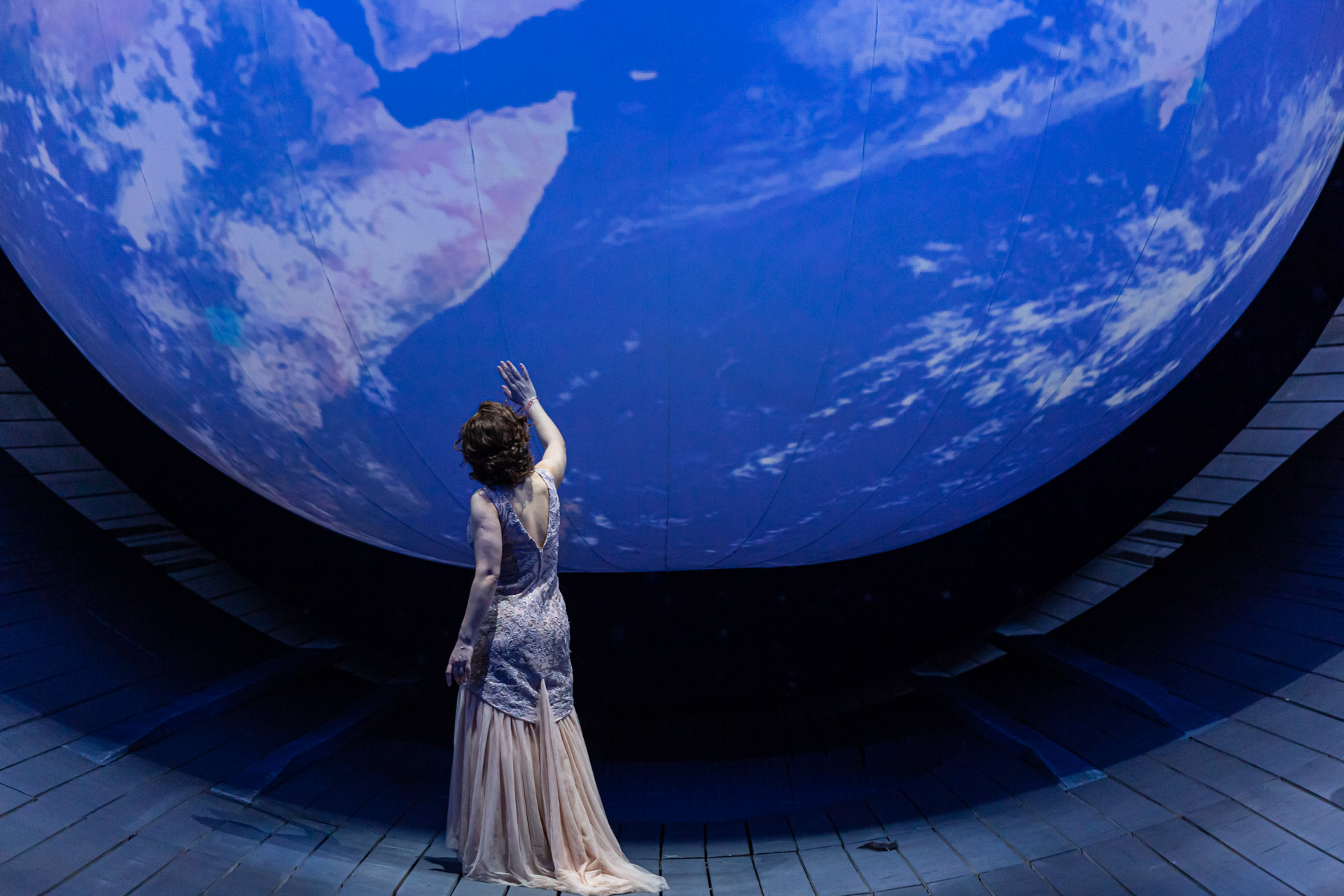 Spectacle à l’Opéra National de Bordeaux : une chanteuse en scène devant un globe terrestre projeté