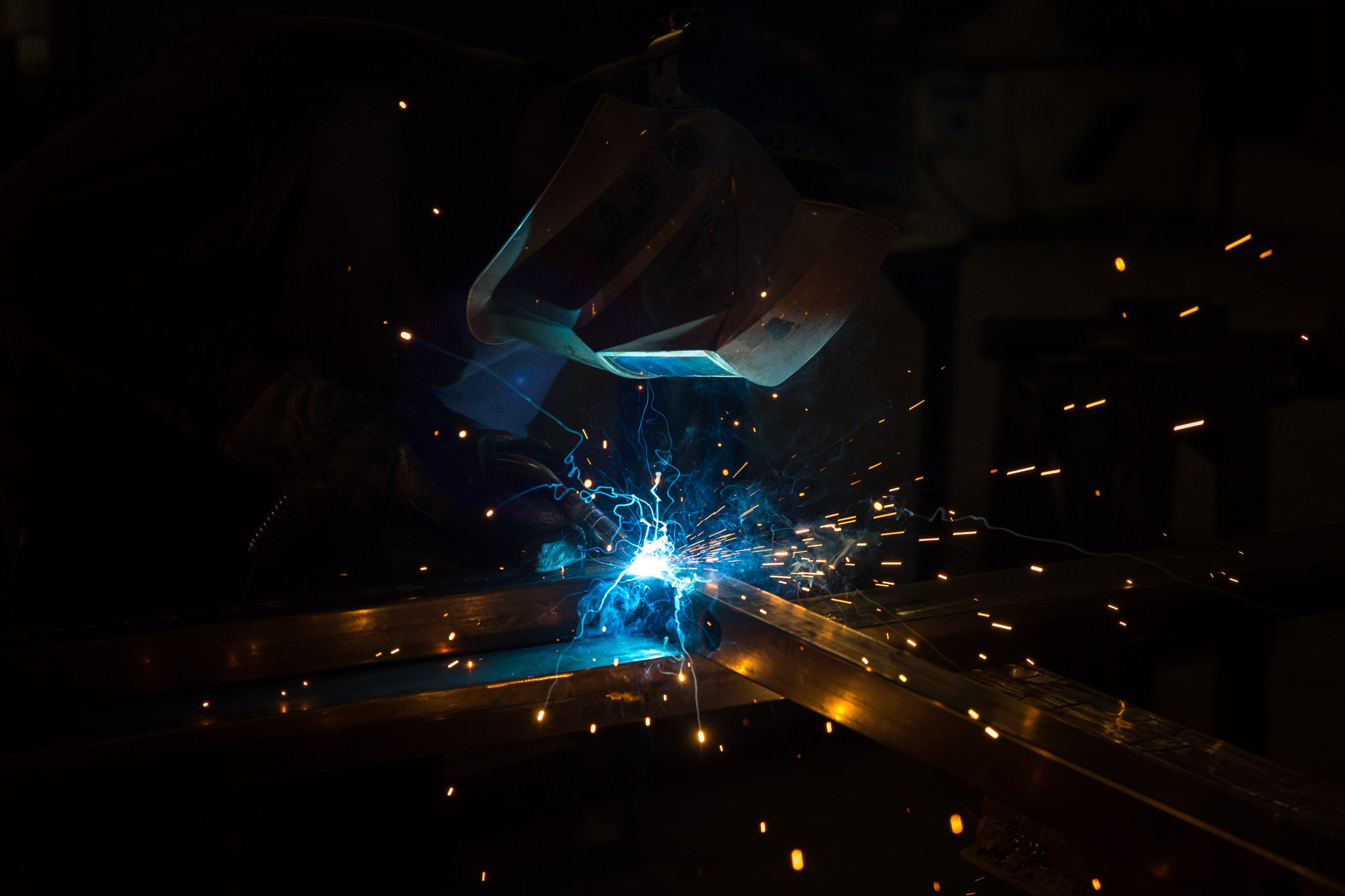 Soudeur à l’arc dans un atelier, gerbe d’étincelles